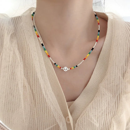 Collana di perline colorate da donna con faccia felice 